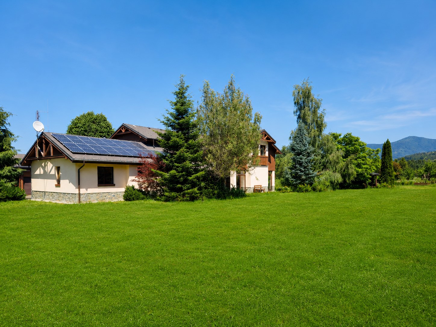 Pohled na dům a zahradu s fotovoltaickými panely